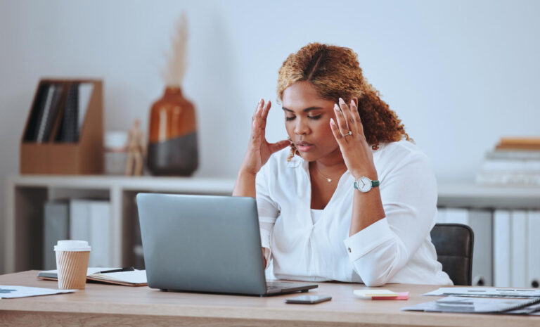 Colaboradora con signos de burnout laboral frente a su computadora en la oficina