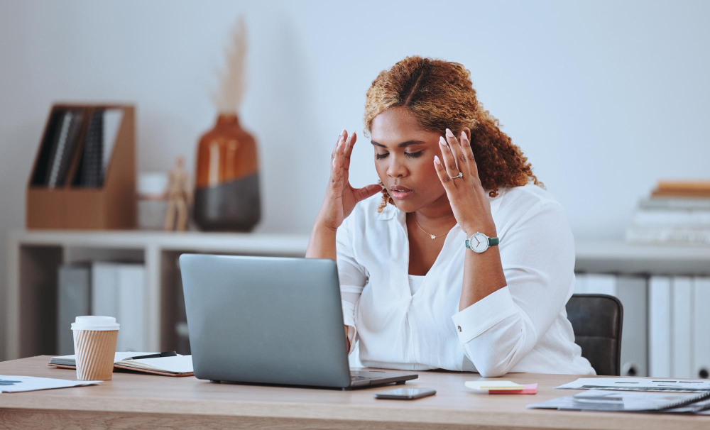 Colaboradora con signos de burnout laboral frente a su computadora en la oficina