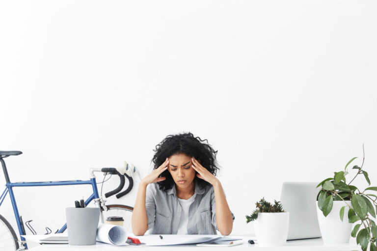 Colaboradora con signos de estrés en su lugar de trabajo, uno de los factores de riesgo psicosocial que regula la NOM-035